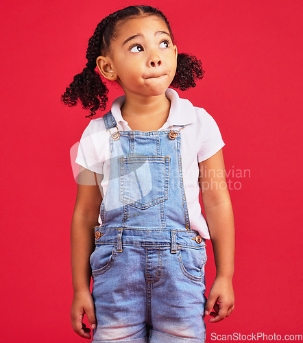 Image of Thinking, girl and red studio background of an isolated young child with an idea and casual fashion. Relax, youth ideas and calm child feeling curious alone with denim dungarees of cute kid