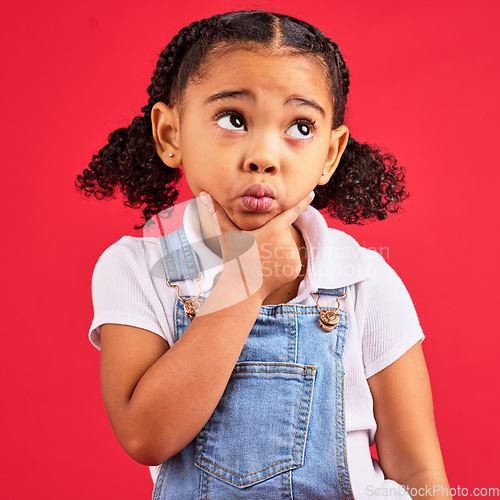 Image of Kid, ideas or thinking face by isolated red background in games innovation, question or planning vision. Little girl, expression or curious finger on chin, children fashion clothes or curly hairstyle