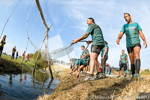 Image of Athletes go through mud and water