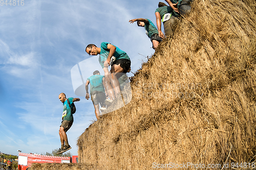 Image of Athletes overcoming the hay osbtacle