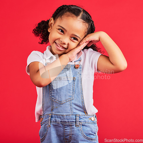 Image of Little girl, cute and shy expression on isolated red background in fashion, trendy or cool clothes and curly hair. Smile, happy child and kid and innocent face, playful or blushing gesture on studio