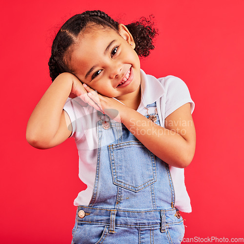 Image of Happy, smile and cute young girl child portrait with red studio background with happiness. Smiling, youth and kid model with denim and adorable hands feeling girly, joyful and positive with fashion
