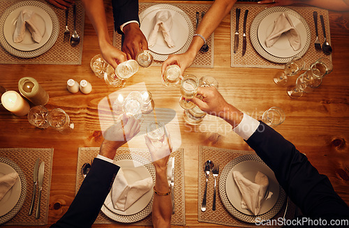 Image of Champagne, glasses and cheers for celebration at a dinner for festive, new years eve or birthday. Party, event and top view of wine for a celebrating toast by a dining table at a restaurant or home.