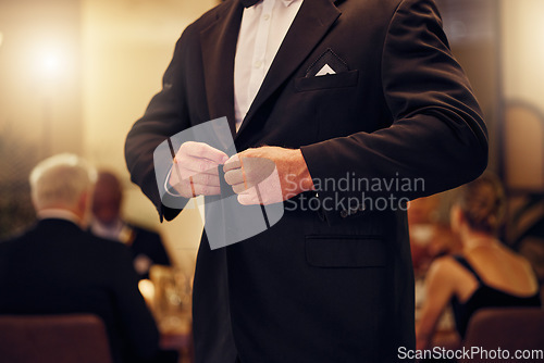 Image of Suit, formal and man tie the button of his jacket at a fancy dinner, party or event banquet. Classy, elegance and male fixing blazer of his elegant outfit at classic supper, celebration or gathering.