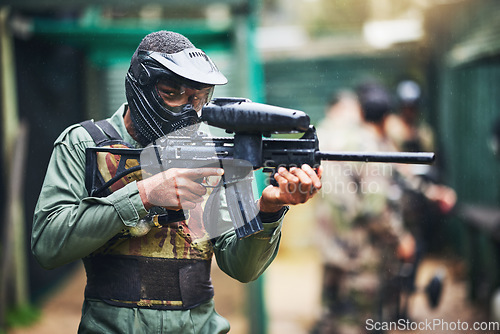 Image of Paintball gun and black man player portrait with safety uniform for outdoor shooting game. Competitive tournament guy with helmet and camouflage vest ready for shooter sport and activity.