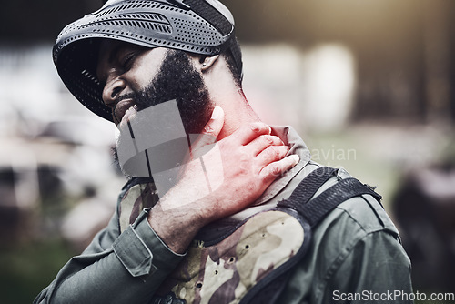 Image of Man, neck pain and paintball injury holding sore area, joint or inflammation in agony after game or match outdoors. Male soldier player in extreme sport suffering from painful ache or shot during war