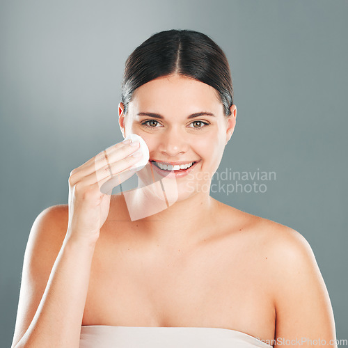 Image of Cotton pad skincare, beauty portrait and wellness woman model cleaning face for wellness and health. Cosmetic, dermatology and facial of a young person with happiness from skin glow and cosmetics