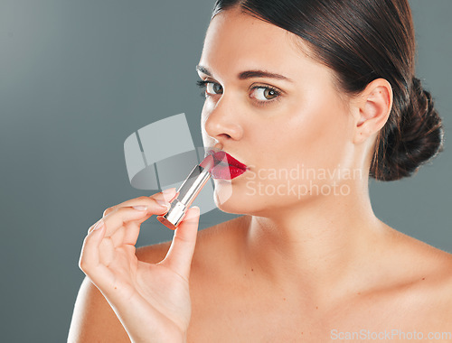 Image of Woman apply lipstick, red on lips and face in portrait with makeup and beauty isolated on studio background. Cosmetic product, skin and skincare glow with wellness, facial and cosmetics shine
