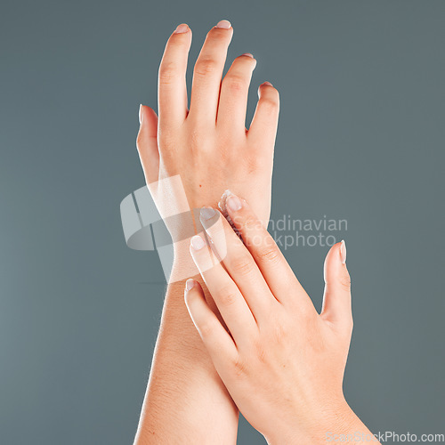 Image of Hands, nail cream and beauty of a woman with moisturizer skincare on arms in studio. Isolated, gray background and person with cosmetic, dermatology and spa lotion for skin and female body glow