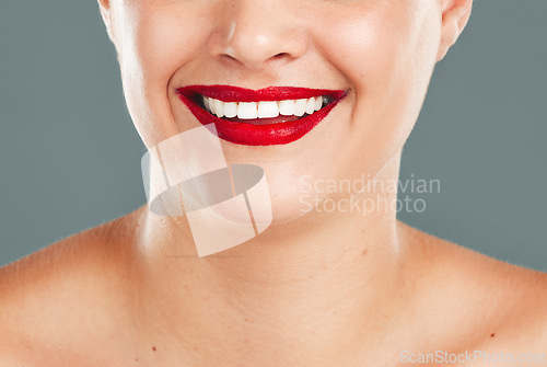 Image of Woman, red lipstick and smile for makeup cosmetics, skincare or beauty against a grey studio background. Happy female model smiling with cosmetic lips or mouth for beautiful color aesthetic treatment