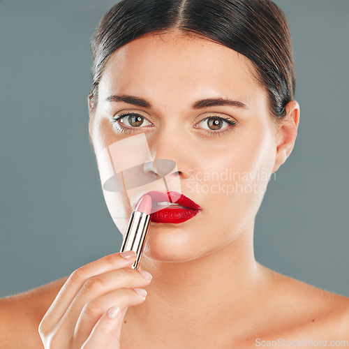 Image of Apply lipstick, woman and face in portrait with lips, red makeup and beauty isolated on studio background. Cosmetic product, skin and skincare glow with wellness, facial with cosmetics shine