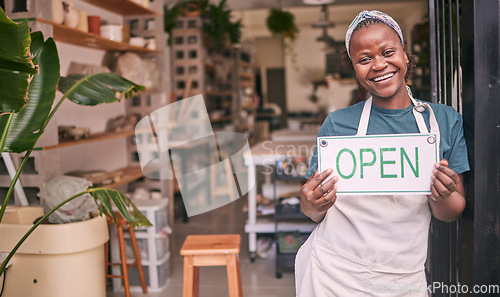 Image of Creative startup, small business and black woman with open sign for art class, workshop and pottery store. Smile, entrepreneur and girl happy for welcome to ceramic, clay sculpture and retail artwork