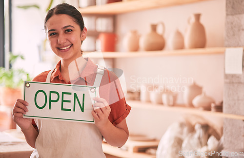 Image of Woman, pottery art and small business with open sign for creative startup, welcome or entrepreneurship at retail store. Portrait of happy entrepreneur with smile holding opening board ready at shop