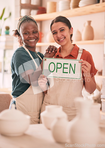 Image of Open sign, collaboration and women with small business for pottery startup, creative workshop and art studio. Retail, welcome and happy females smile for ceramics, clay sculpture and artwork store