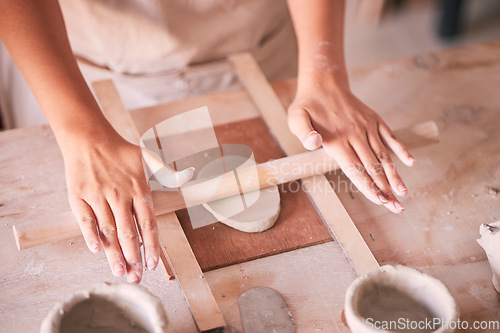 Image of Ceramics, pottery and design with hands of woman in workshop studio for mold, creative and art. Clay, sculpture and manufacturing with girl artisan rolling on table for crafting, handmade and hobby