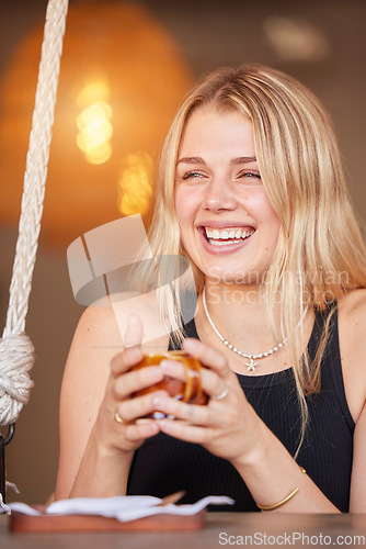 Image of Happy, young and woman at cafe with coffee in cup and cheerful smile enjoying break at table. Laugh, youth and happiness of girl customer with drink at casual restaurant with bokeh light.