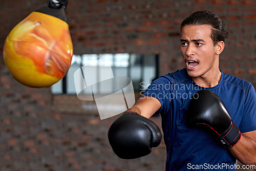 Image of Gym fitness and boxer man punch for sports workout, training and athlete practice with equipment. Energy, focus and power of young martial arts fighter guy at kickboxing and wellness club.