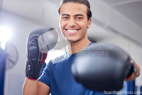 Image of Fitness, portrait or happy boxer in training, cardio workout or exercise in a sports gym or health club. Face, man or healthy fighter in boxing gloves exercising with motivation, focus or goals
