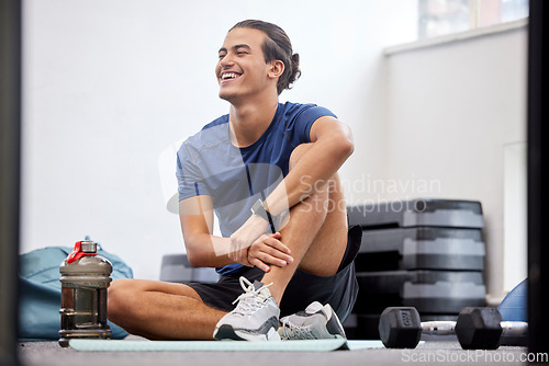 Image of Fitness, relax or happy sports man at gym after training, workout or exercise resting on a break. Tired, smile or healthy athlete with fatigue relaxing on a mat alone after exercising for body goals