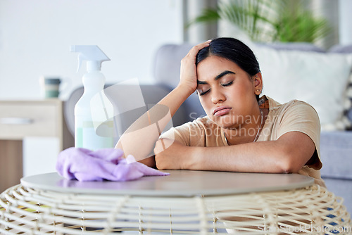 Image of Cleaning, burnout and bored with a woman in the living room of her home for hygiene or housework. Depression, tired and housekeeping with a frustrated female cleaner in an apartment domestic work