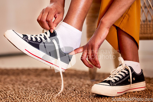 Image of Hands, shoes and lace getting ready for walk, travel or shopping on the carpet floor or mat at home. Hand of person tying laces, fitting or putting on shoe in preparation for walking, journey or trip