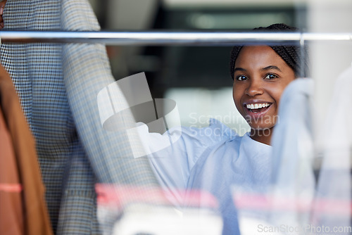 Image of Shopping, clothes and face of black woman in store with choice on rack for sale, discount and promotion. Fashion, designer boutique and happy girl customer with clothing, outfit and retail products