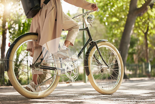 Image of Bicycle, closeup and feet of casual cyclist travel on a bike in a park outdoors in nature for a ride or commuting. Exercise, wellness and lifestyle student cycling as sustainable transport