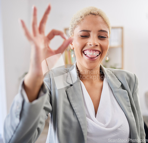 Image of Portrait, tongue and emoji with a business black woman winking in her office at work to gesture a perfect hand sign. Face, motivation and succes with a female employee feeling happy or proud