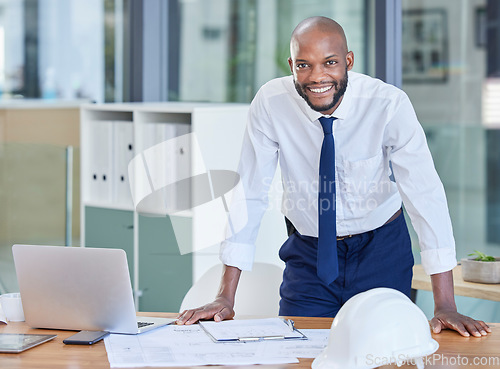 Image of Portrait, black man and architect in office, laptop and achievement with startup, manager or smile. Nigerian male employee, confident leader or engineer with blueprints, happiness or business success