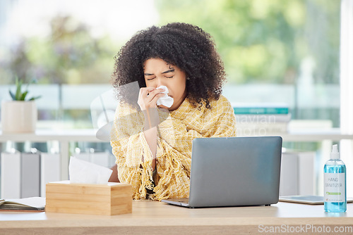 Image of Sick, laptop and blowing nose with a business back woman using a tissue while working in her office. Computer, covid and sneezing with a young female employee wrapped in a blanket while ill at work
