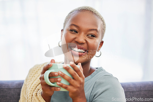 Image of Black woman, relax and sofa with drink, coffee and smile in home living room for me time. Young African lady, peace or tea on couch for happiness, self care and chilling in house, apartment or room