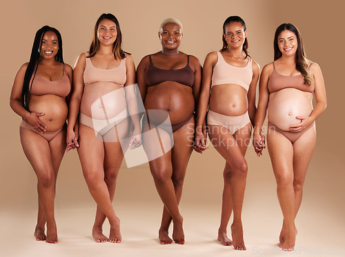 Image of Pregnant, women or diversity portrait with stomach on studio background in body love, baby or community support. Smile, happy or pregnancy friends in underwear for tummy growth or mothers empowerment
