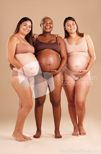 Image of Pregnant, body and portrait of women in stomach support touch, hope and community diversity on studio background. Smile, happy and pregnancy friends in underwear, belly growth and healthcare wellness