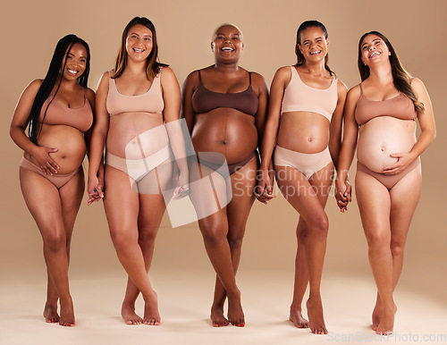 Image of Pregnant, women or portrait of holding hands in support, body empowerment or studio background community. Happy smile, pregnancy or friends underwear for belly growth, diversity pride or mothers day