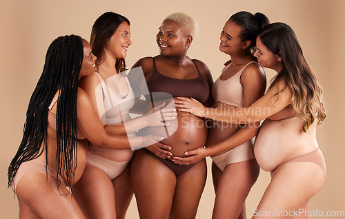 Image of Happy women, hands or touching pregnant stomach of black woman on studio background in support, love or life insurance. Smile, bonding or friends in pregnancy underwear and feeling baby kick in belly