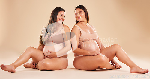 Image of Women, bonding or sitting with pregnant stomach, tummy growth progress or baby healthcare wellness on studio background. Smile, happy or friends in pregnancy underwear for solidarity support or love