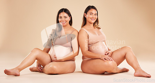 Image of Women, portrait or sitting and pregnancy stomach, tummy growth progress or baby healthcare wellness on studio background. Smile, happy or friends in pregnant underwear for solidarity support or love