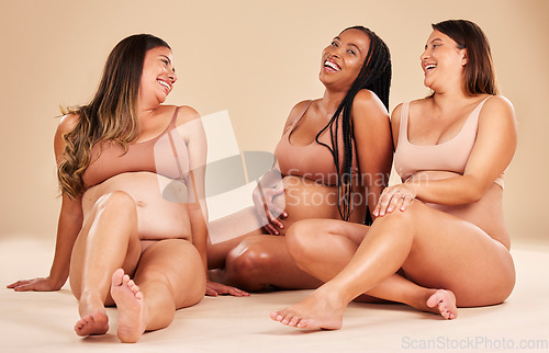 Image of Pregnant, body or laughing women sitting on studio background floor in diversity support, mothers day or relax trust. Happy smile, pregnancy or bonding friends in underwear, belly or funny comic joke