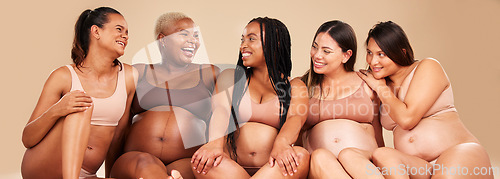 Image of Laughing, bonding and pregnant women sitting on floor in community, diversity support or body wellness. Smile, happy and pregnancy friends in underwear with funny, comedy or comic joke for healthcare