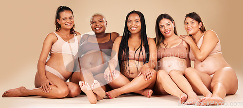 Image of Portrait, group or pregnancy friends sitting in underwear in community bonding, diversity support or body empowerment. Happy smile, floor or pregnant women in healthcare wellness, future baby or love