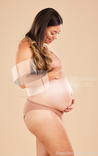 Image of Pregnancy care, underwear and studio woman with smile, happy and excited for baby, stomach growth or motherhood. Gynecology, maternity or pregnant model feeling abdomen with healthcare, love and hope