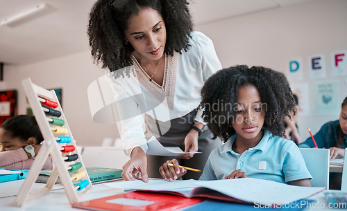 Image of Math, education or teacher helping a child in a classroom with learning development, growth or studying. Writing, notebook or black woman teaching, talking or speaking to a young African boy student