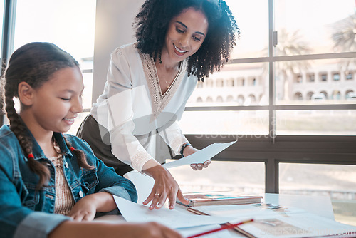 Image of Help, education or teacher teaching a student in a classroom with learning development or studying. Writing, papers or happy black woman helping, talking or speaking to a creative high school girl