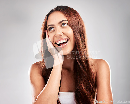 Image of Hair, thinking and woman in studio for beauty, grooming and salon treatment on grey background. Smile, haircare and model relax with luxury, hair care and shine, keratin and contemplating isolated