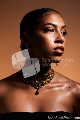 Image of Fashion, elegant and woman with jewellery in a studio with classy, fancy and stylish accessories. Luxury, beauty and female model with gold, vintage and retro jewelry isolated by a brown background.