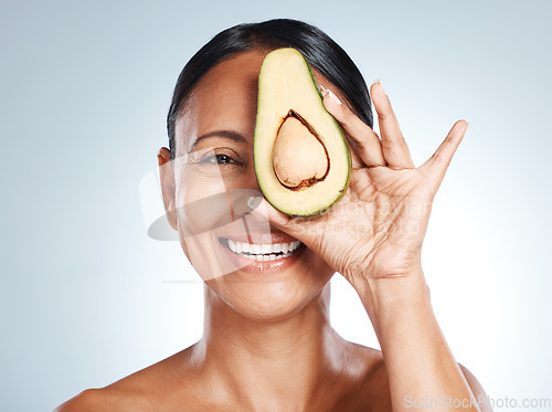 Image of Beauty, avocado and portrait of woman in studio happy, detox and nutrition on grey background. Fruit, product and face of girl model relax, facial and vegan skincare, skin and and mask while isolated