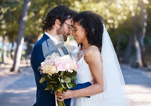 Image of Married couple, flower bokeh and smile for commitment, marriage or love together in the park. Happy groom and bride smiling in happiness for honeymoon, romance and embracing relationship in nature