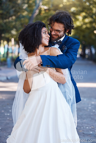 Image of Happy couple, hug and wedding celebration event outdoor with love, care and commitment. Interracial man and woman at park with trust, partnership and support while together in a healthy marriage