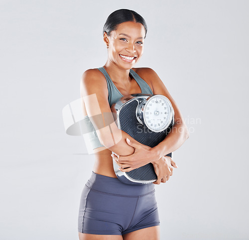 Image of Diet, portrait and scale with a black woman athlete in studio on a gray background for body positivity or health. Fitness, weightloss and losing weight with a young female posing for wellness