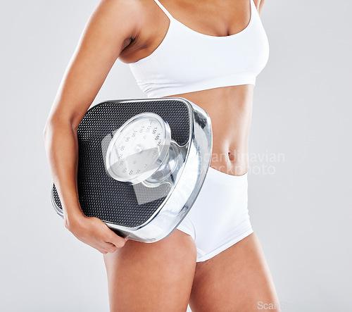 Image of Wellness, fitness and body of woman with scale in studio after workout, exercise and training to lose weight. Motivation, self care and female model for nutrition, diet routine and healthy lifestyle